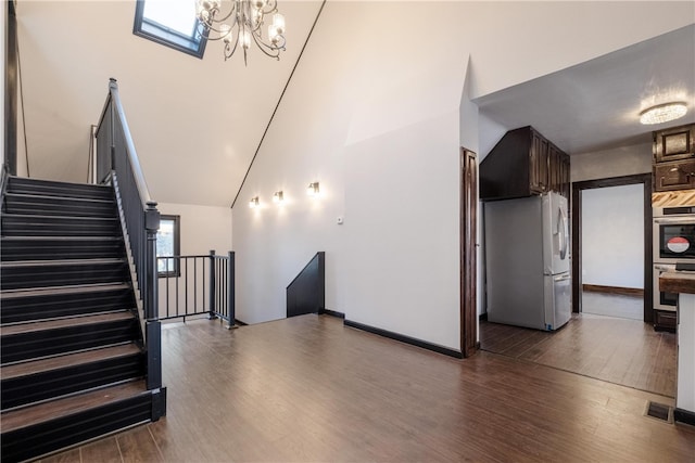 staircase with wood-type flooring and vaulted ceiling