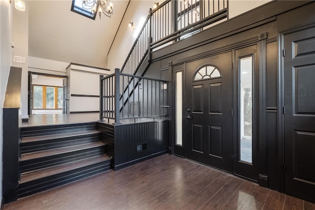 entryway with high vaulted ceiling and dark hardwood / wood-style flooring