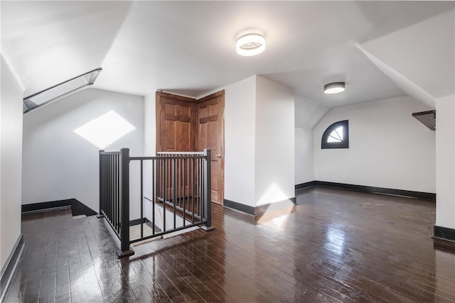 bonus room with vaulted ceiling and dark hardwood / wood-style floors