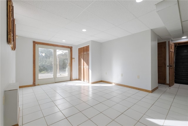 tiled spare room featuring a paneled ceiling