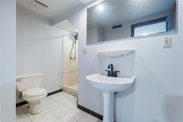 bathroom featuring toilet, a shower, and tile patterned floors