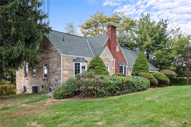 view of side of property featuring a yard and cooling unit