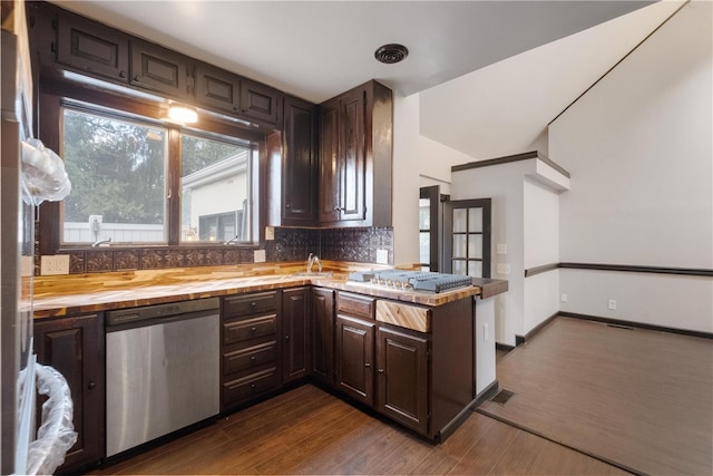 kitchen with wooden counters, appliances with stainless steel finishes, dark brown cabinetry, and dark hardwood / wood-style floors