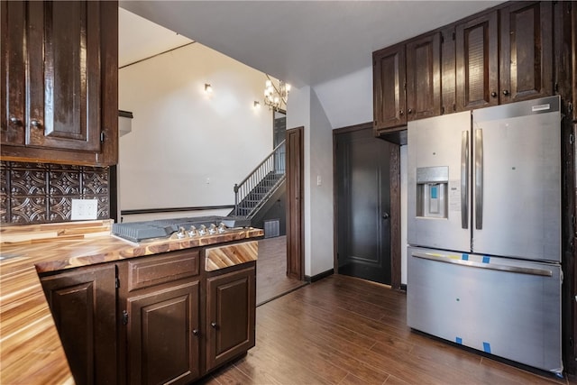 kitchen with wood counters, dark brown cabinetry, decorative backsplash, stainless steel fridge with ice dispenser, and dark hardwood / wood-style floors