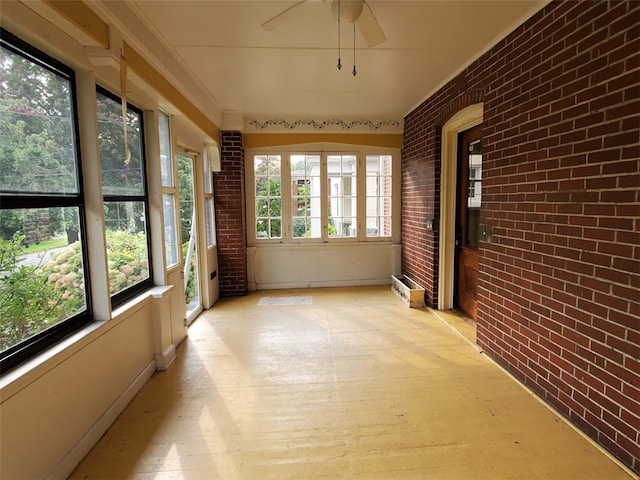 unfurnished sunroom with ceiling fan