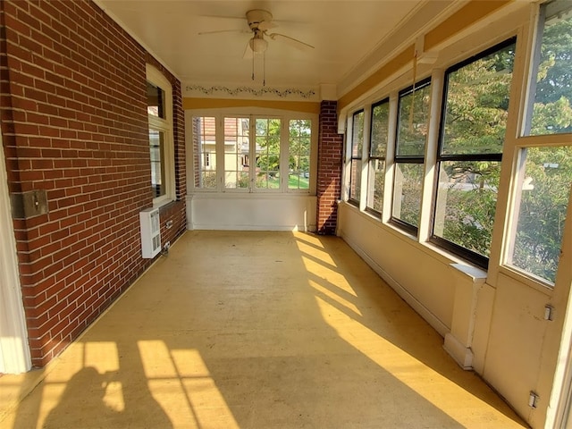 unfurnished sunroom with ceiling fan