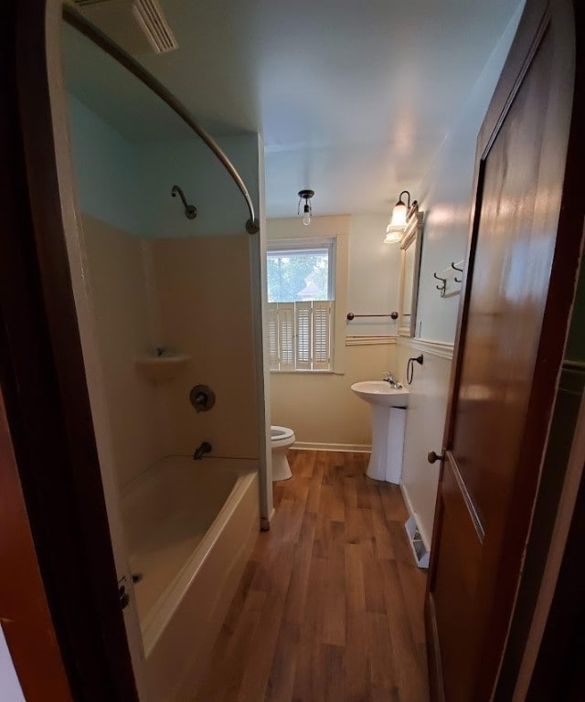 full bathroom with vanity, shower / washtub combination, hardwood / wood-style floors, and toilet