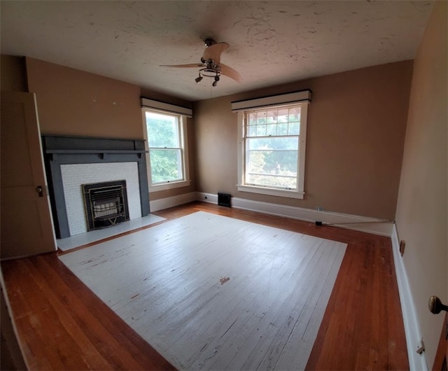 unfurnished living room featuring ceiling fan and hardwood / wood-style flooring