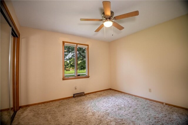 carpeted empty room featuring ceiling fan