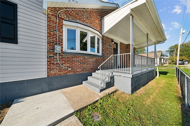 property entrance with a lawn