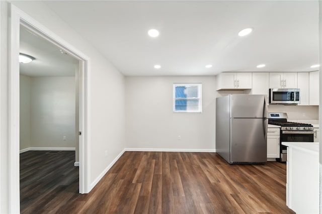 kitchen featuring appliances with stainless steel finishes, dark wood-type flooring, and white cabinets