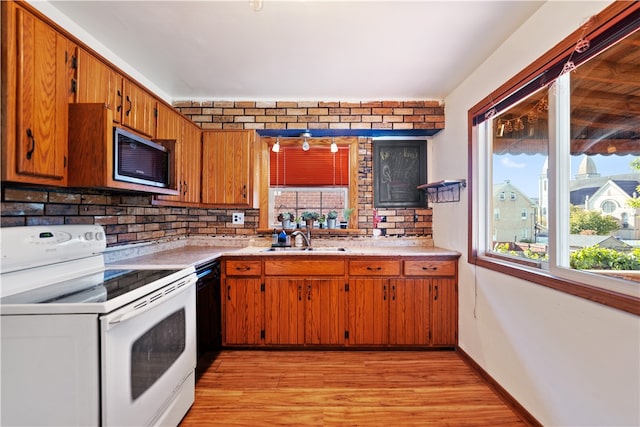 kitchen with sink, white electric stove, black dishwasher, light hardwood / wood-style floors, and decorative backsplash