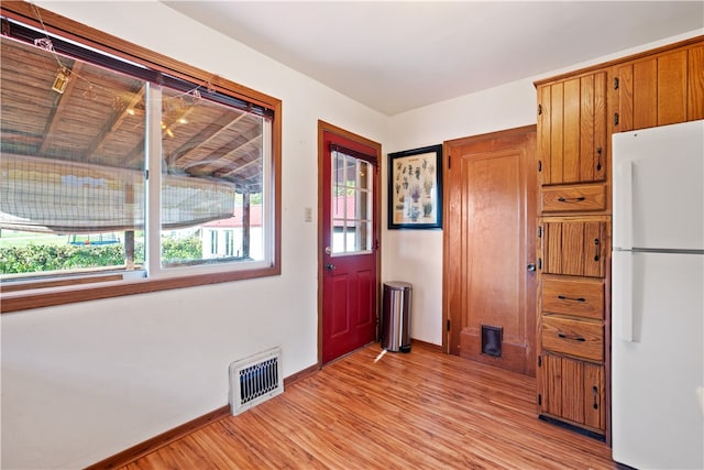 interior space with light wood-type flooring and white refrigerator