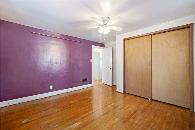 unfurnished bedroom featuring ceiling fan, a closet, and hardwood / wood-style floors