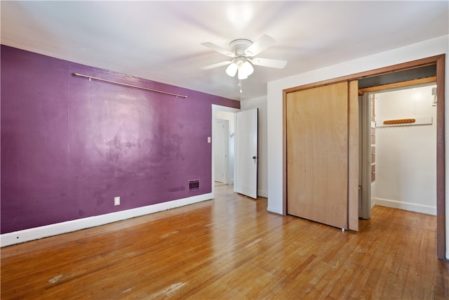 unfurnished bedroom with ceiling fan, a closet, and light hardwood / wood-style floors