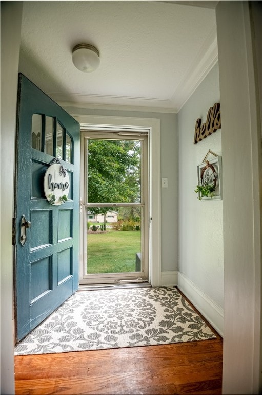 doorway with hardwood / wood-style floors and crown molding