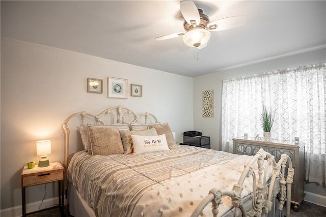 bedroom with dark carpet, multiple windows, and ceiling fan