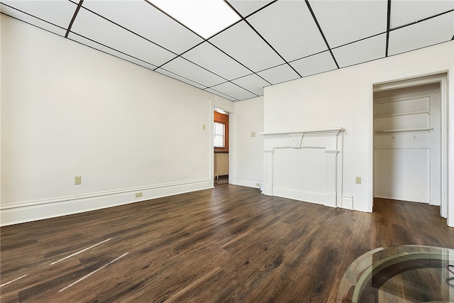 unfurnished living room with a drop ceiling and hardwood / wood-style floors