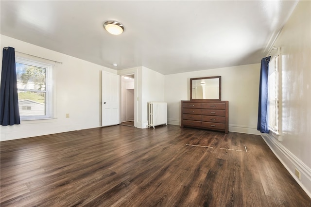 unfurnished bedroom with radiator and dark hardwood / wood-style floors