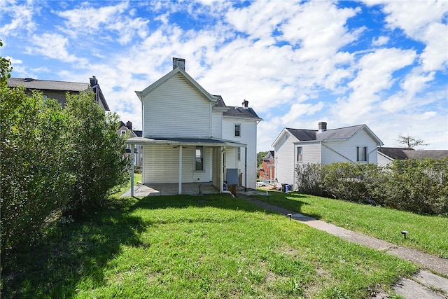 rear view of property featuring a lawn and a patio