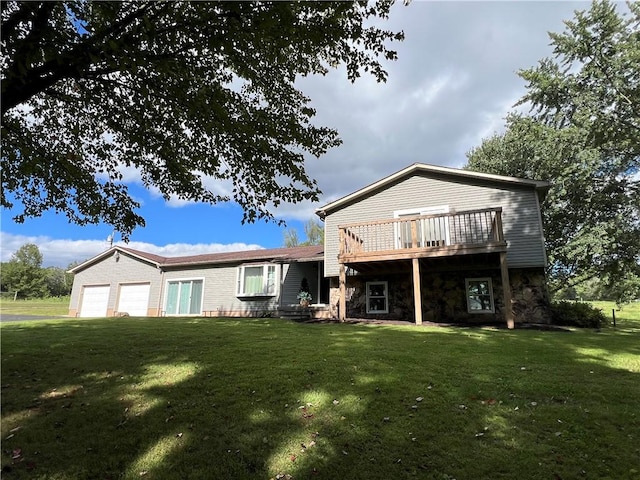 rear view of property with a garage, a wooden deck, a yard, and stone siding