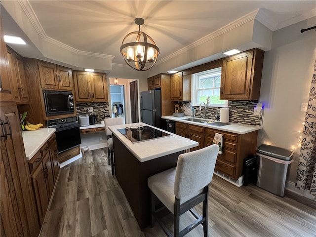 kitchen with black appliances, a center island, dark hardwood / wood-style floors, and tasteful backsplash