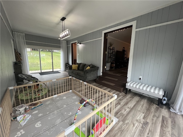 interior space featuring wooden walls, crown molding, and hardwood / wood-style flooring