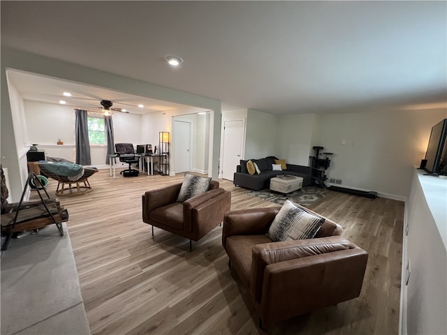 living room with wood-type flooring and ceiling fan