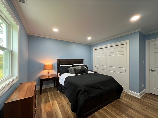 bedroom with a closet, crown molding, and wood-type flooring