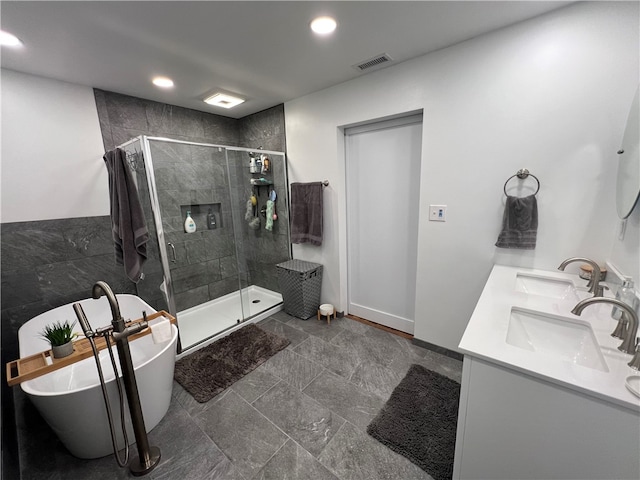 bathroom featuring vanity and independent shower and bath