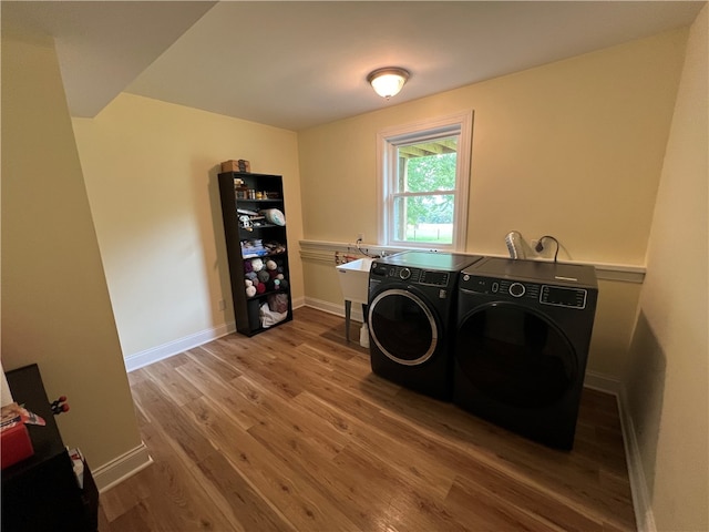 washroom with wood-type flooring and washer and clothes dryer