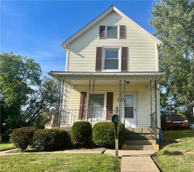 view of front of house with a front yard and a porch