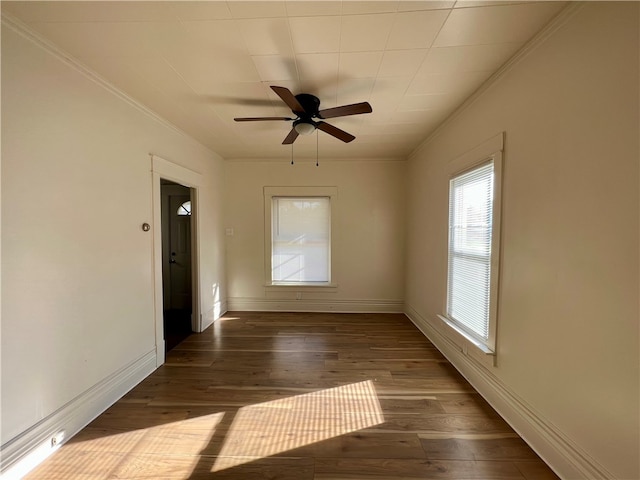 empty room with ceiling fan, dark hardwood / wood-style floors, and ornamental molding