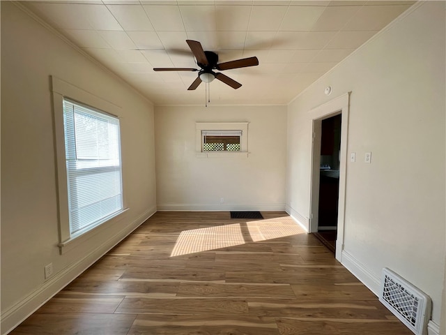 unfurnished room featuring ornamental molding, ceiling fan, and dark wood-type flooring