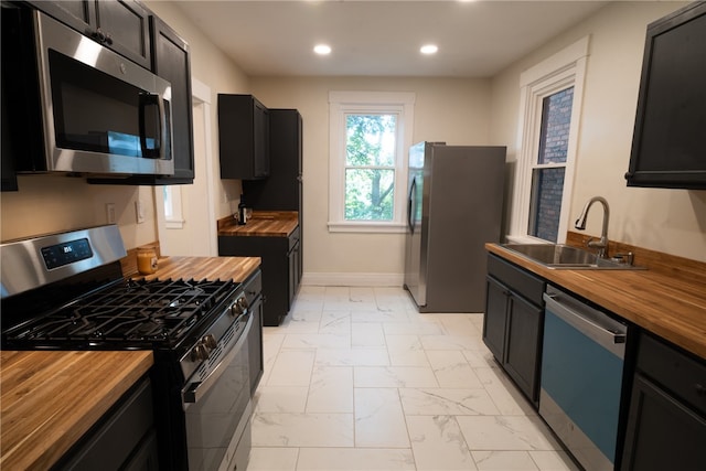 kitchen featuring butcher block countertops, appliances with stainless steel finishes, and sink