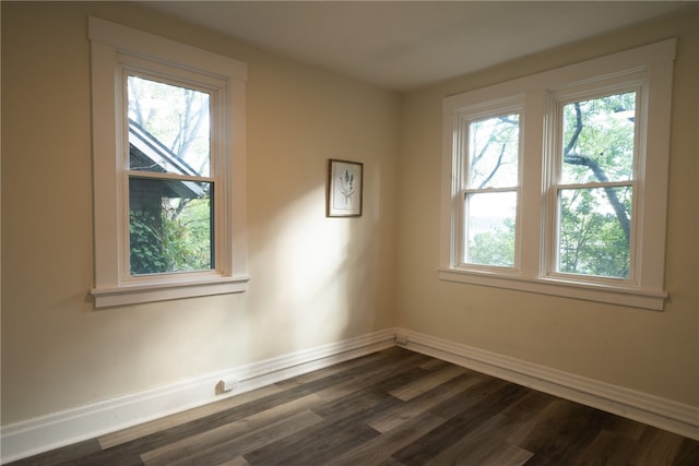 empty room with a healthy amount of sunlight and dark hardwood / wood-style flooring