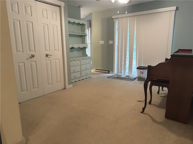 interior space with light carpet, a baseboard heating unit, and ceiling fan