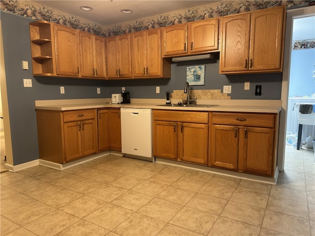 kitchen featuring light tile patterned floors, dishwasher, and sink