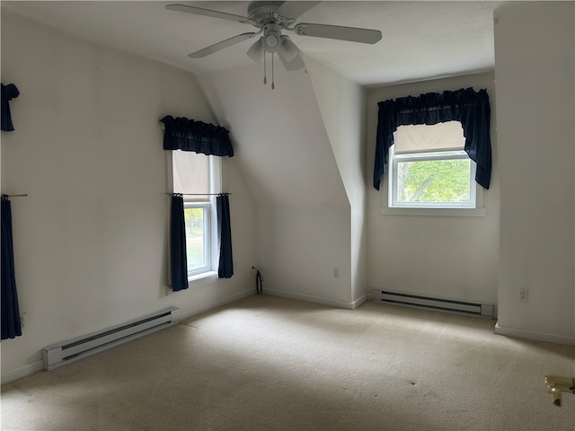 interior space featuring a baseboard heating unit, vaulted ceiling, and a healthy amount of sunlight