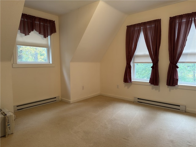 additional living space with a baseboard radiator, vaulted ceiling, and light colored carpet