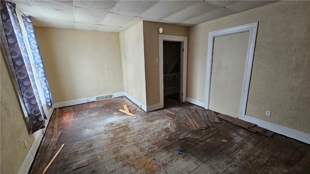 empty room featuring hardwood / wood-style floors and a paneled ceiling