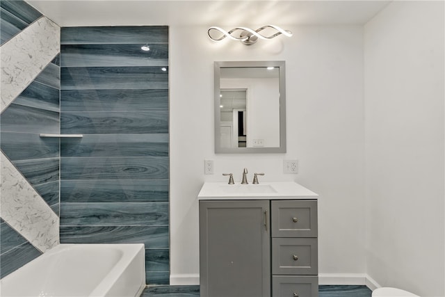 bathroom with vanity, a washtub, and hardwood / wood-style flooring