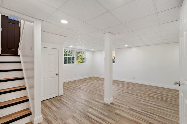 basement with light hardwood / wood-style floors and a drop ceiling