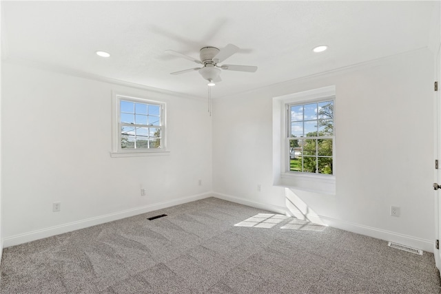 unfurnished room featuring crown molding, carpet flooring, ceiling fan, and a wealth of natural light