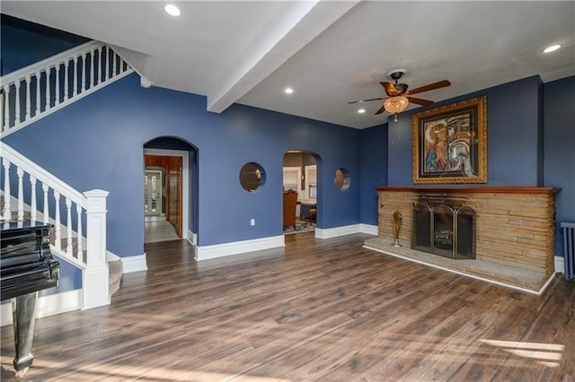 living room featuring ceiling fan, beamed ceiling, and dark wood-type flooring