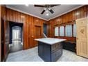 kitchen with crown molding, wooden walls, and a center island