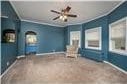 interior space with a healthy amount of sunlight, carpet flooring, ornamental molding, and ceiling fan