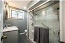 bathroom featuring vanity and a shower with shower door