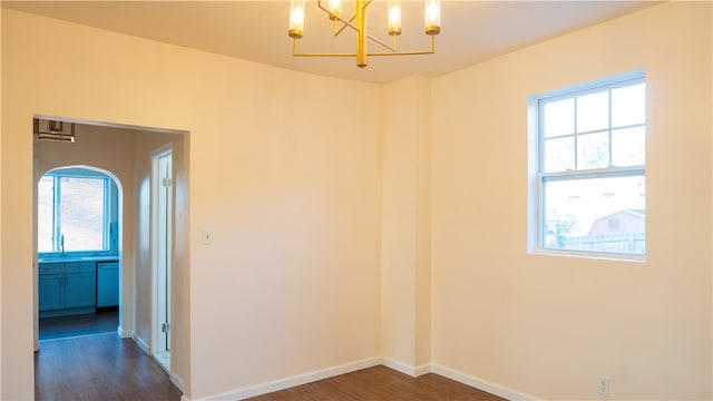 spare room featuring an inviting chandelier, dark hardwood / wood-style floors, and sink