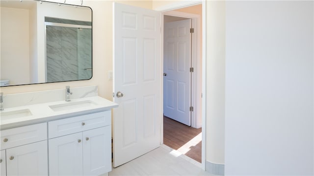 bathroom featuring wood-type flooring, walk in shower, and vanity